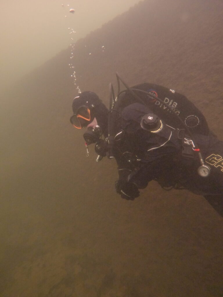 Side photograph of a diver trying the Camaro drysuit