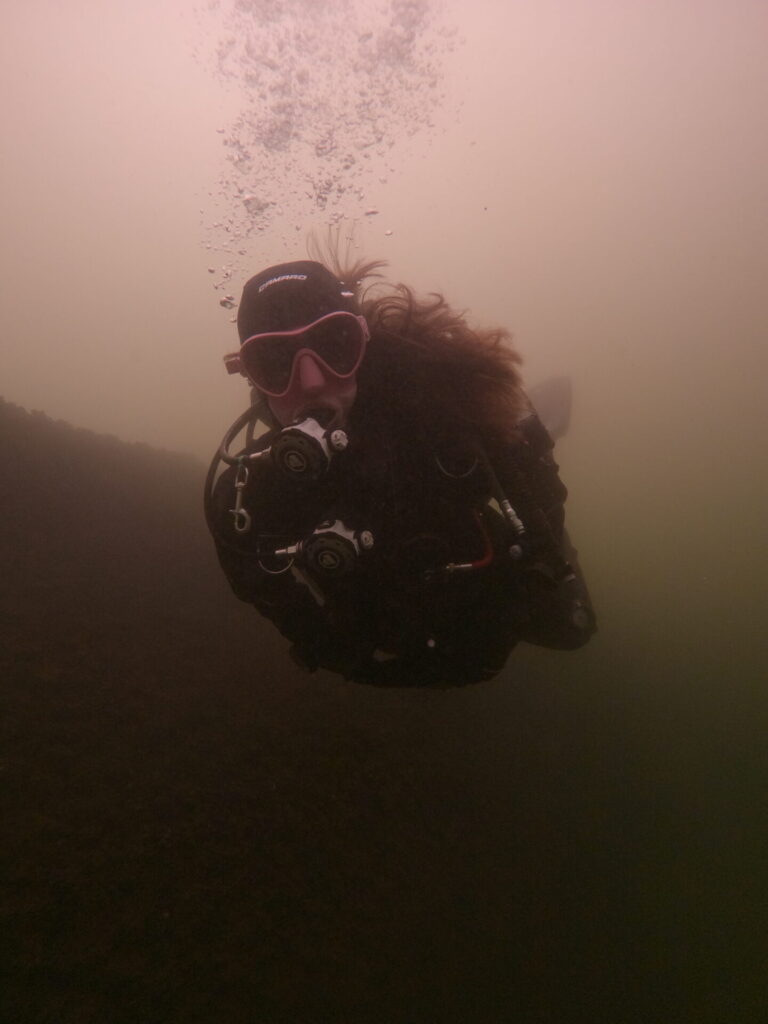 Diver with long hair floating effortlessly with the Camaro drysuit